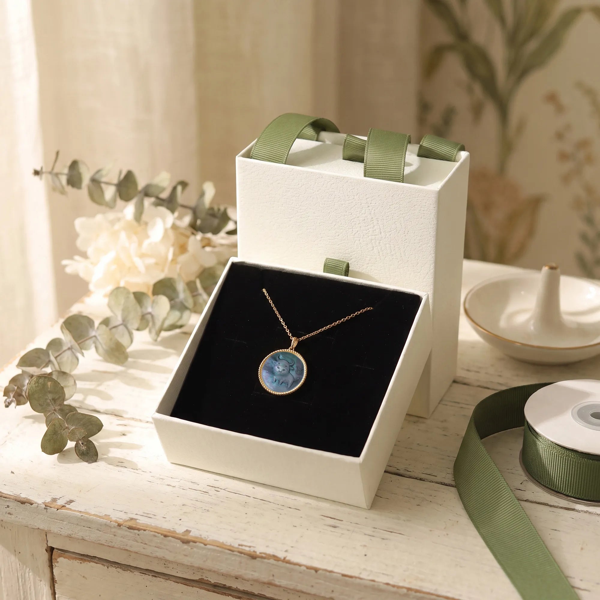 Kawaii zodiac necklace gift packaging featuring white drawer box, black cushion insert and gold-plated mother-of-pearl pendant by OceanCarvingLab.
