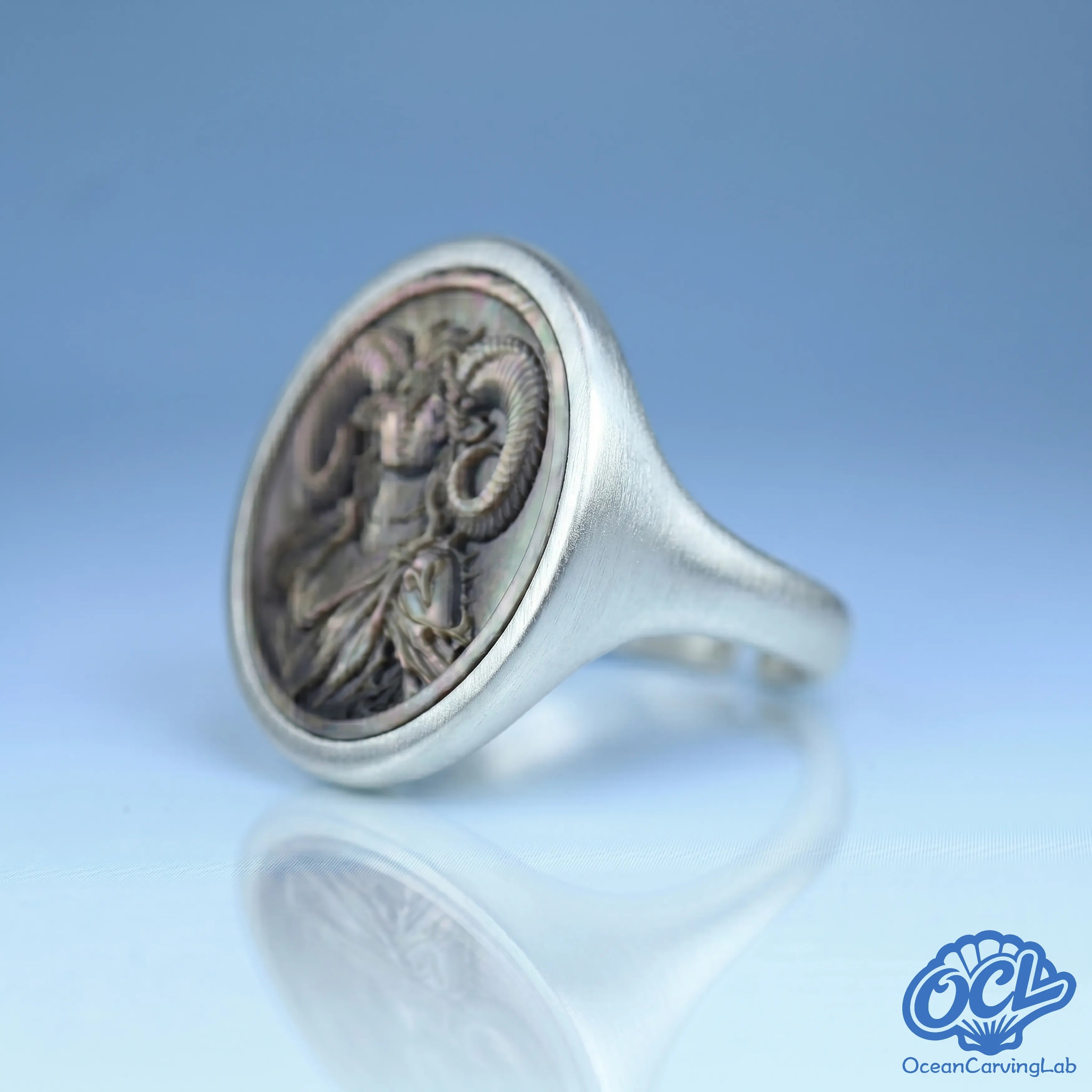 Close-up of hand-engraved ram figure on black mother-of-pearl inlay - Aries ring by OceanCarvingLab