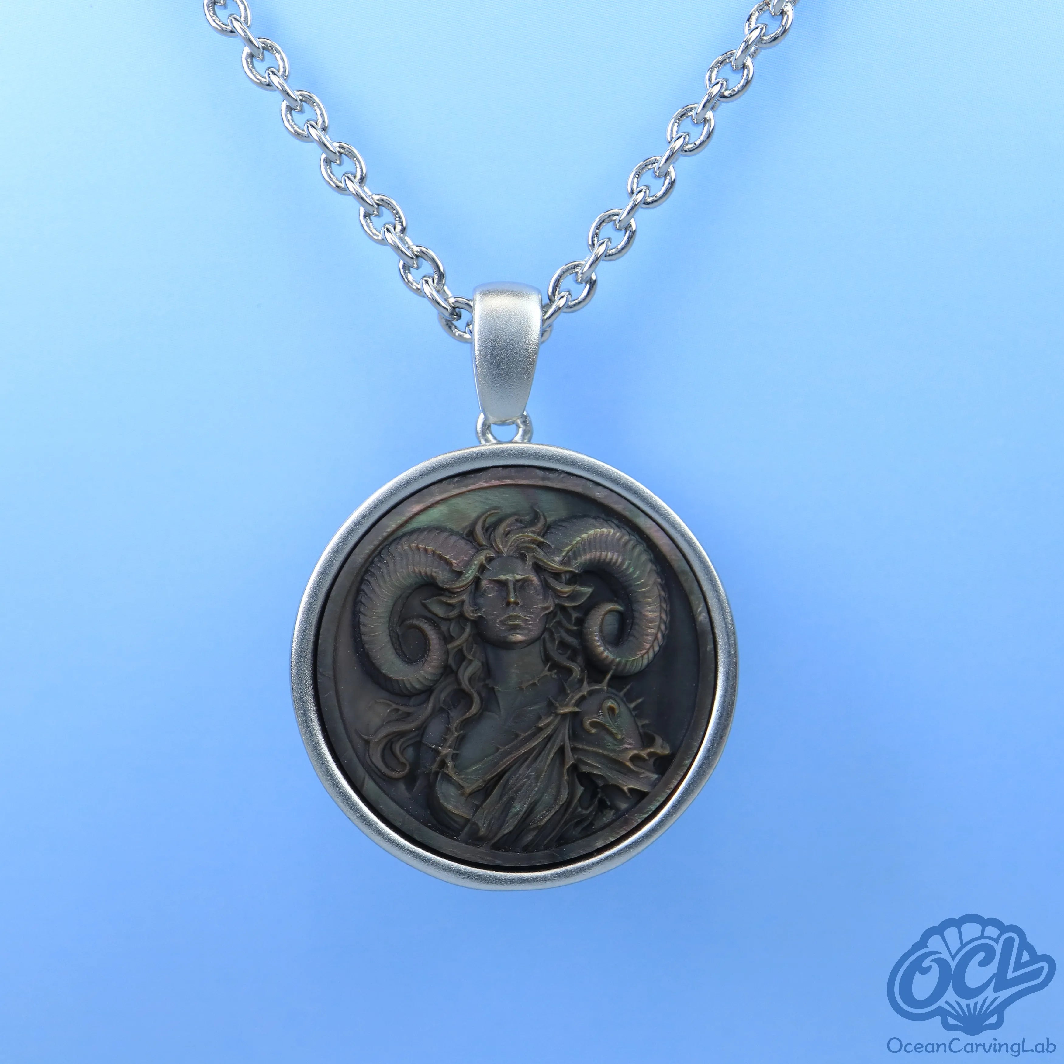 Detailed Aries ram engraving on a round natural shell disc, reflecting soft pearlescent light.