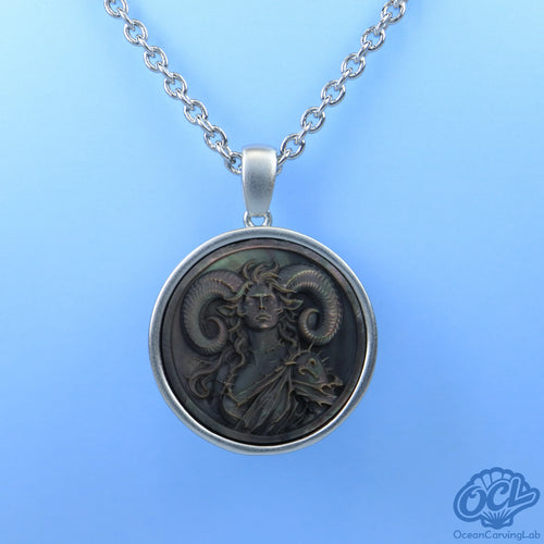 Detailed Aries ram engraving on a round natural shell disc, reflecting soft pearlescent light.