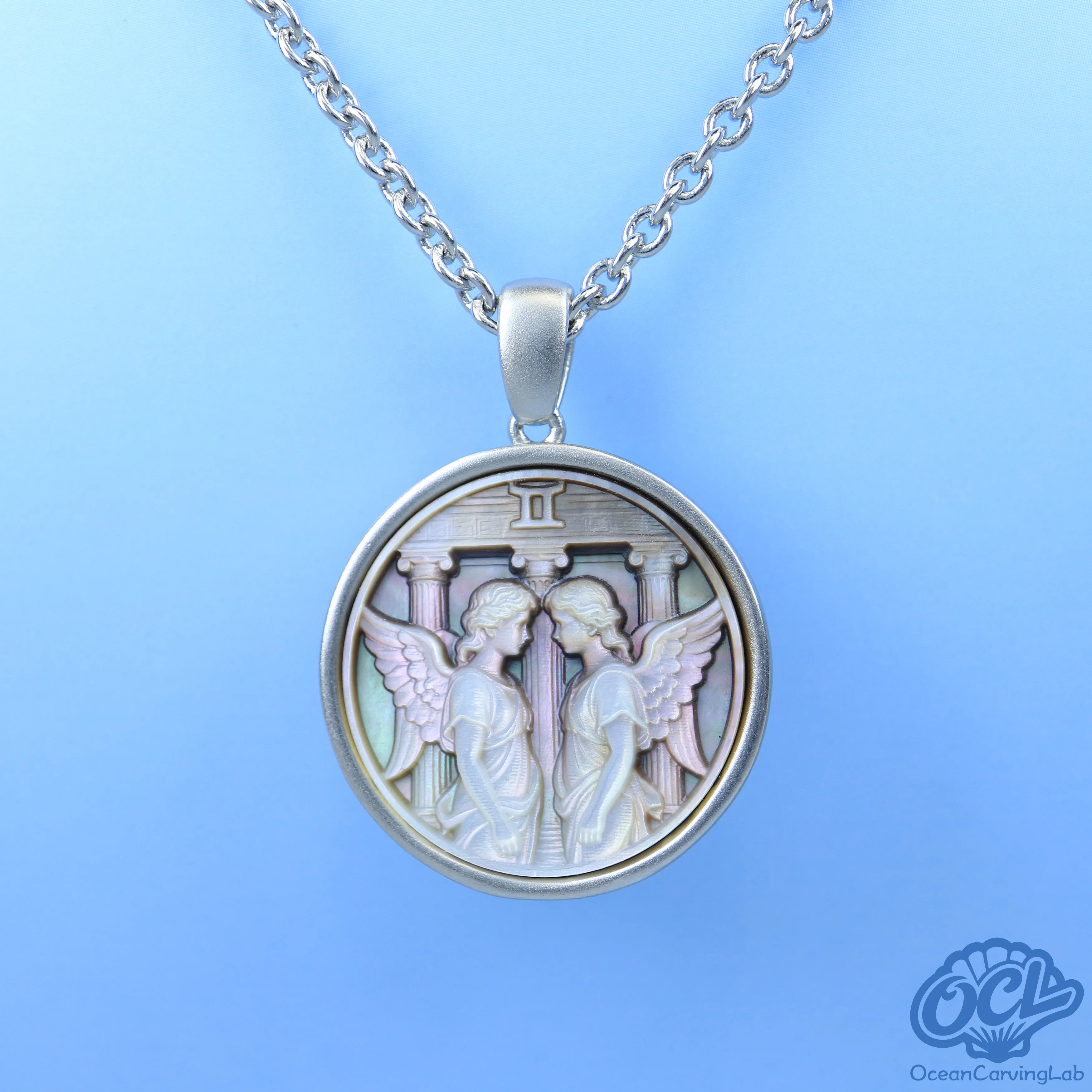 Gemini twins figure engraved on white iridescent mother of pearl using CNC technology.
