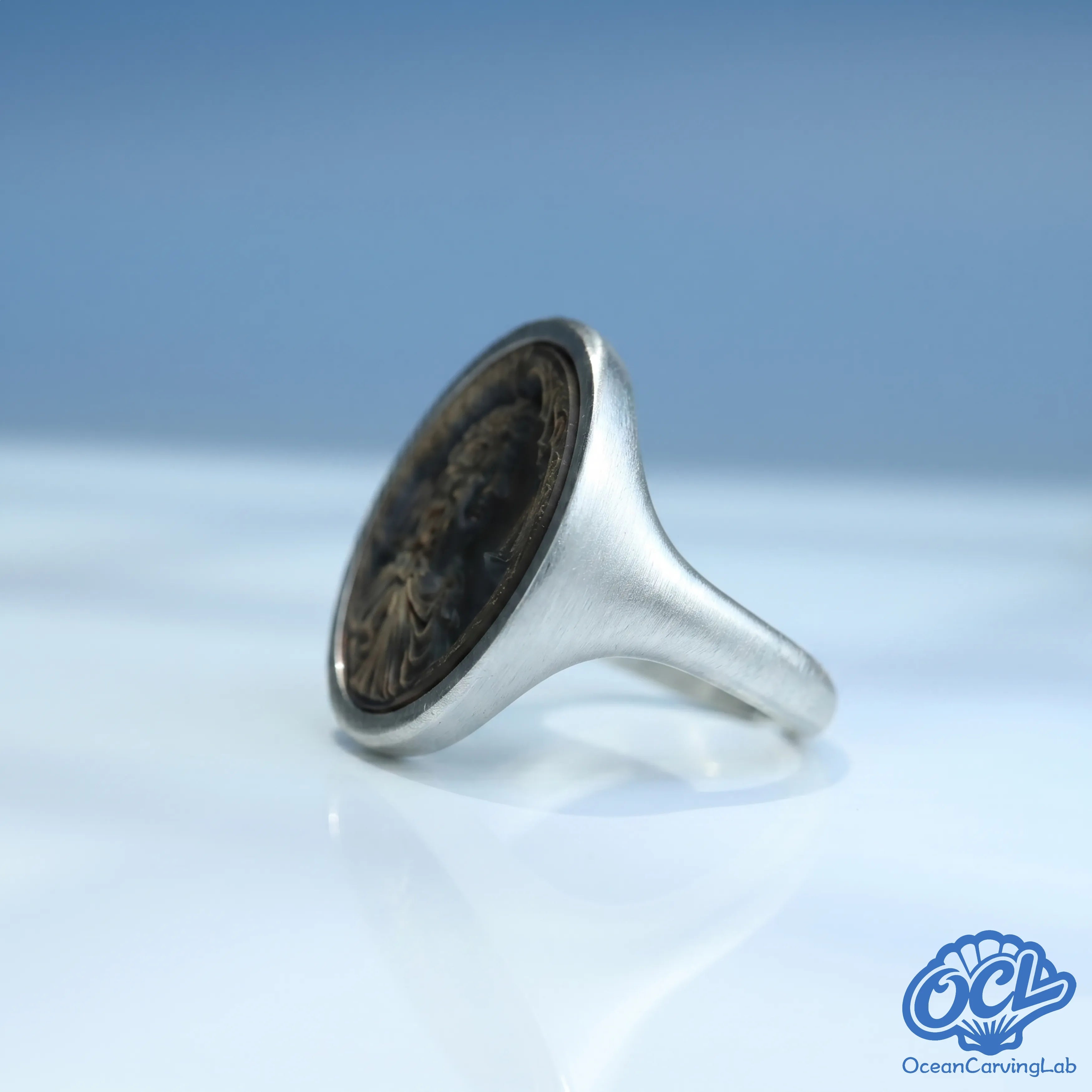 Balanced Libra ring with a high-luster gold finish and manual natural shell inlay.