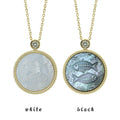 Two Pisces zodiac pendant necklaces with carved black and white mother-of-pearl inlay on white background by Celestial Creations.